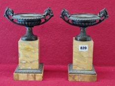 A PAIR OF 19th C. BRONZE TWO HANDLED URNS RAISED ON SQUARE SECTIONED OCHRE MARBLE COLUMNS WITH