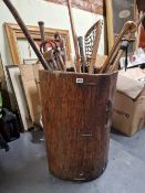A LARGE ANTIQUE DUG OUT TREE TRUNK STICK STAND CONTAINING NUMEROUS WALKING STICKS, UMBRELLAS AND