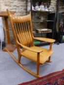 TWO BLOND WOOD ROCKING CHAIRS, ONE WITH A RUSH SEAT AND STICK BACK AND THE OTHER WITH A SADDLE