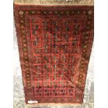 A BELOUCH TRIBAL PRAYER RUG. 148 x 96cms TOGETHER WITH A VINTAGE HOOKED RUG. 140 x 86cms (2)
