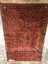 A BELOUCH TRIBAL PRAYER RUG. 148 x 96cms TOGETHER WITH A VINTAGE HOOKED RUG. 140 x 86cms (2)