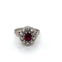 AN 18ct WHITE GOLD HALLMARKED AND HIGH QUALITY RUBY AND DIAMOND CLUSTER RING. THE OVAL CLAW SET RUBY