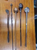 THREE AFRICAN BALL HEADED WOODEN CLUBS, POSSIBLY ZULU, A WALKING CANE WITH A SIMILAR BALL HANDLE