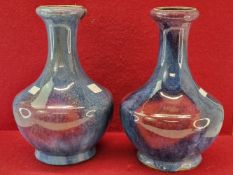 A PAIR OF CHINESE LONG NECKED VASES GLAZED IN JUN STYLE IN BLUE SPLASHED WITH RASPBERRY TONES. H