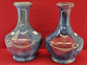 A PAIR OF CHINESE LONG NECKED VASES GLAZED IN JUN STYLE IN BLUE SPLASHED WITH RASPBERRY TONES. H