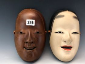 TWO JAPANESE CARVED WOOD MASKS OF LADIES, ONE PAINTED. H 21cms. TOGETHER WITH A GROTESQUE MASK,