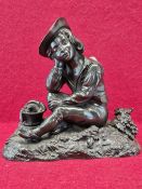 A BRONZE FIGURE OF A BOY TRAVELLER SEATED AMONGST GRAPES WITH HIS EYES CLOSED AND A BOTTLE AND