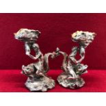 A PAIR OF ELECTROPLATE SALTS IN THE FORM OF A MERMAID AND A MERMAN RIDING DOLPHINS AND HOLDING UP