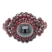 AN ANTIQUE VICTORIAN BOHEMIAN GARNET BANGLE . THE HINGED BANGLE ASSESSED AS SILVER AND GILDING,