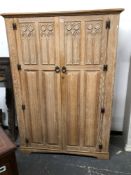 A LIMED OAK WARDROBE WITH GOTHIC AND LINEN FOLD PANELLED DOORS TOGETHER WITH A SINGLE BED WITH OAK