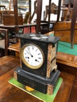 A BLACK SLATE CASED CLOCK STRIKING ON BELL