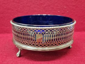 A SILVER TRIPOD COASTER AND BLUE GLASS LINER, LONDON 1775, INITIALLED TO ONE OF THE PIERCED SIDES.