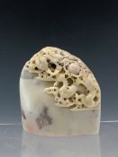 A CHINESE AGATE SEAL PIERCED AND CARVED WITH TWO DRAGONS HEAD TO HEAD WITH A PEARL. H 8Ccms., A