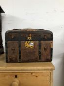 AN IRON STRAP BOUND LEATHER COVER TRUNK WITH A ROUND ARCH LID. W 40cms.