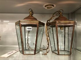 A PAIR OF COPPER AND BRASS MOUNTED HANGING HALL LANTERNS