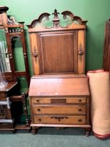 A CARVED WALNUT AMERICAN STYLE SECRETARY CABINET.