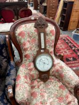 AN EDWARDIAN CARVED OAK BAROMETER