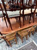 A KRISTOFFERSEN TEAK TABLE, THE CIRCULAR TOP AND COLUMN TO EXTEND TO TAKE LEAVES AND SUPPORTED ON