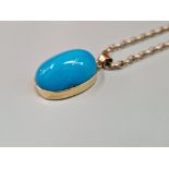 A VINTAGE CARBOCHON TURQUOISE PENDENT IN AN UNHALLMARKED 14ct GOLD MOUNT SUSPENDED ON A 9ct