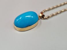 A VINTAGE CARBOCHON TURQUOISE PENDENT IN AN UNHALLMARKED 14ct GOLD MOUNT SUSPENDED ON A 9ct