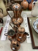 FIVE MIDDLE EASTERN COPPER EWERS TOGETHER WITH A COPPER MUG
