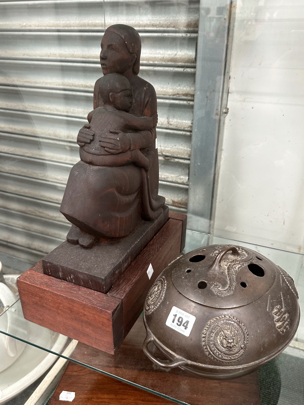 A CHINESE BRONZE CENSER AND COVER TOGETHER WITH A WOODEN CARVING OF A MOTHER WITH HER CHILD ON HER