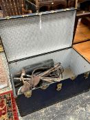 A VINTAGE METAL BOUND TRAVELLING TRUNK TOGETHER WITH VARIOUS RIDING BOOTS, WHIPS ETC.