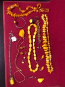 A COLLECTION OF AMBER, RESIN AND OTHER JEWELLERY TO INCLUDE A ROSE CARVED PENDENT ON A CONTINENTAL