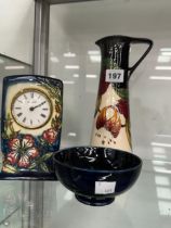 A MOORCROFT CASED TIMEPIECE, A EWER AND A BOWL