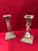 A PAIR OF LOADED SILVER HALLMARKED CANDLESTICKS.
