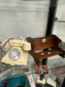 A WHITE TELEPHONE TOGETHER WITH A DOUBLE SIDED OAK BOOK RACK