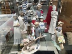 A COLLECTION OF LLADRO, NAO, AND OTHER FIGURUINES INCLUDING A LAMP BASE.