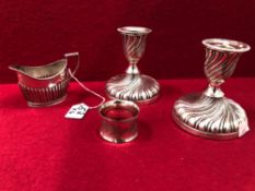 A PAIR OF LOADED HALLMARKED SILVER CANDLESTICKS, A JUG AND NAPKIN RING.