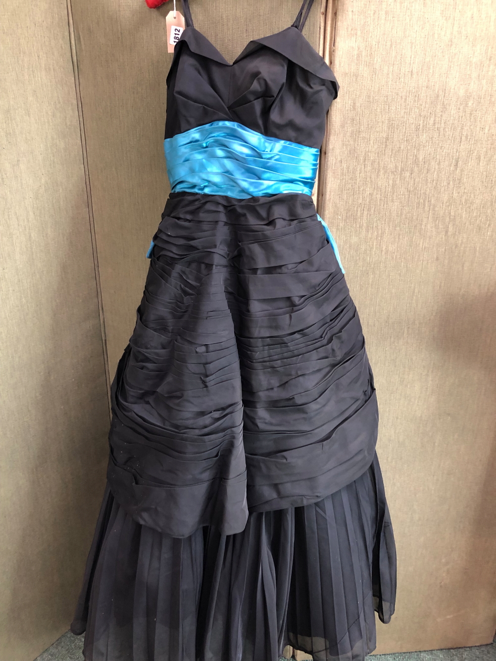 A BLACK EVENING DRESS WITH BRIGHT BLUE RIBBON