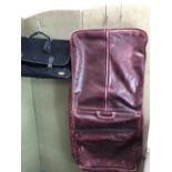 A BURGUNDY HEAVY LEATHER SUIT CARRIER WITH A BLACK SUEDETTE TRAVEL BAG (2)