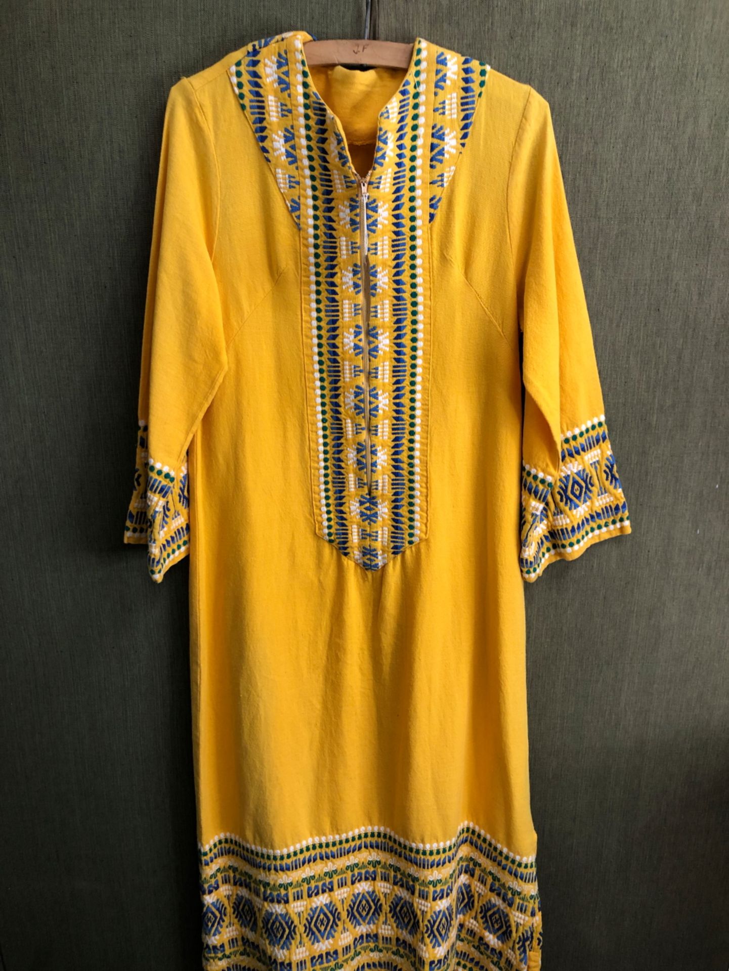 KAFTAN: A YELLOW GROUND KAFTAN DRESS TRIMMED WITH BLUE, GREEN AND WHITE GEOMETRIC BANDS, SLEEVE