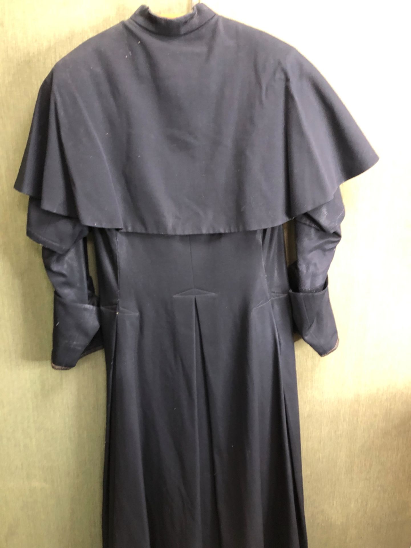 CASSOCK. A ROMAN CATHOLIC PRIESTS BLACK CAPED CASSOCK WITH LEATHER BOUND SLEEVE CUFFS, SHOULDER TO - Image 7 of 7