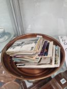 A COPPER BOWL CONTAINING A SMALL COLLECTION OF POSTCARDS