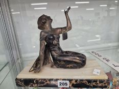 AN ART DECO SPELTER FIGURE OF A LADY HOLDING HER LEFT HAND UP WHILE KNEELING ON A RECTANGULAR MARBLE