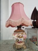 A CERAMIC OIL LAMP CONVERTED TO ELECTRICITY AND DECORATED WITH FLOWERS AND BIRDS