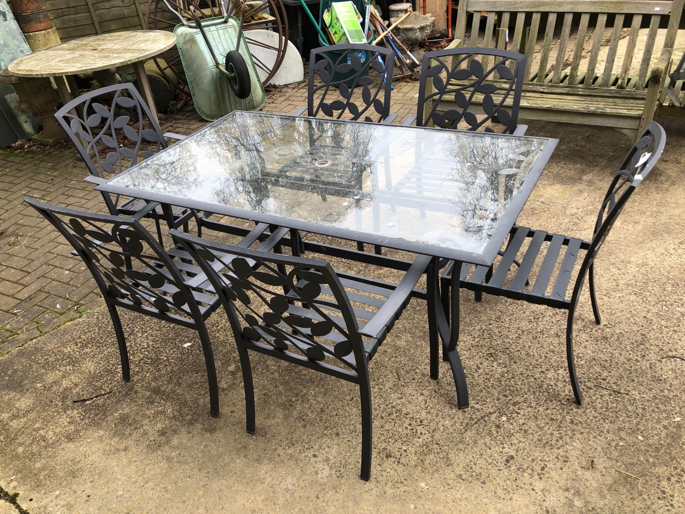 A GLASS AND METAL GARDEN TABLE WITH SIX MATCHING CHAIRS