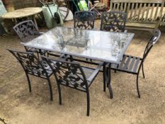 A GLASS AND METAL GARDEN TABLE WITH SIX MATCHING CHAIRS