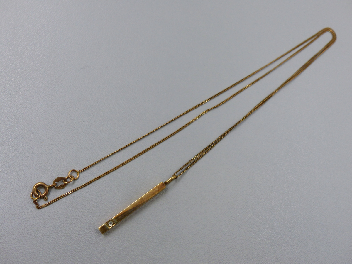 A 9ct HALLMARKED GOLD DIAMOND SET BAR PENDANT,DROP 3cms, SUSPENDED ON A CURB LINK CHAIN. LENGTH OF