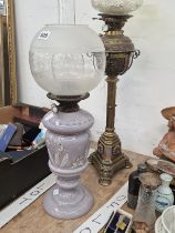 A BRASS AND A MAUVE RISE AND FALL BURNER DUPLEX GLASS OIL LAMP