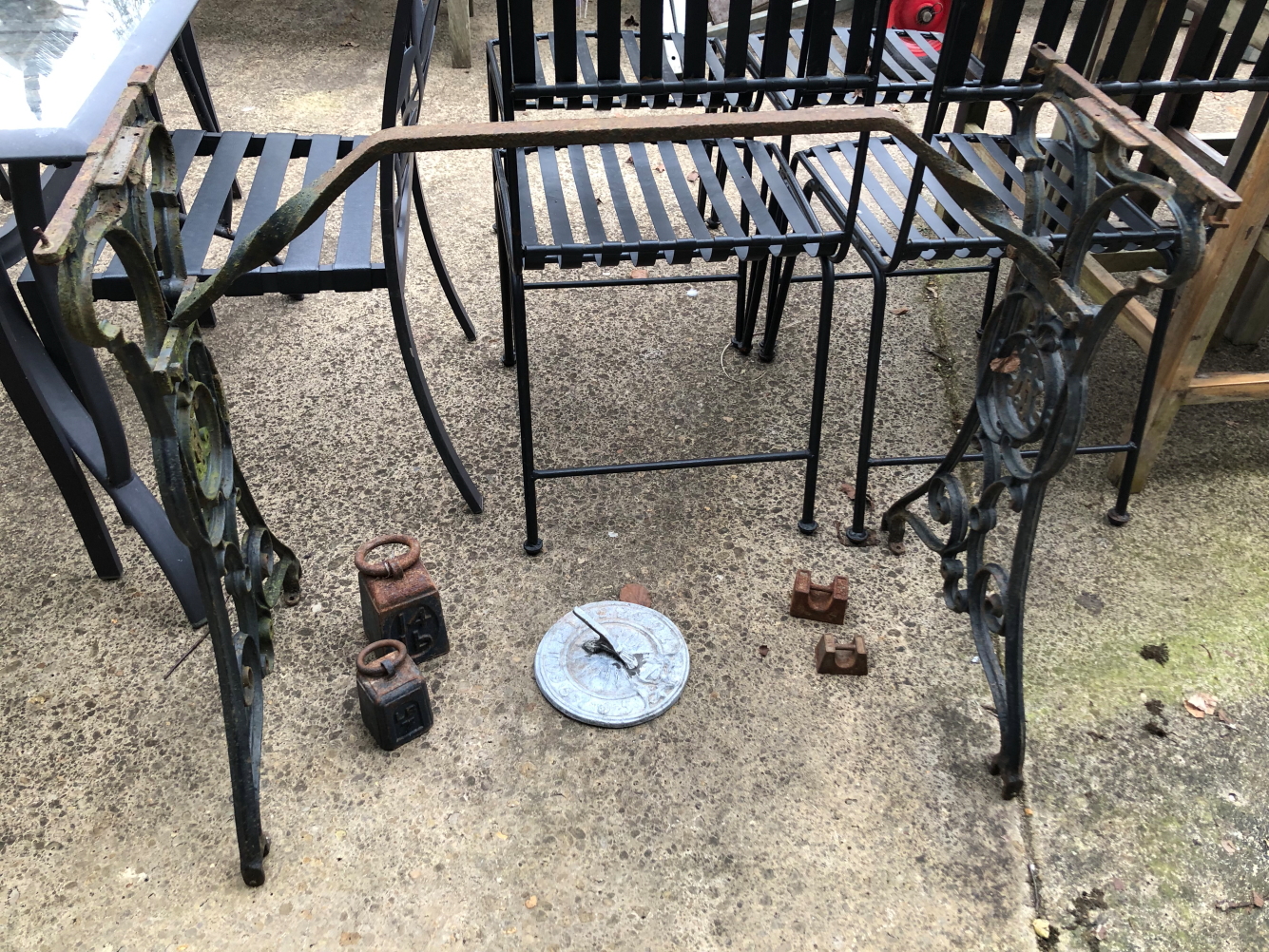 A CAST IRON SEWING MACHINE BASE TOGETHER WITH A LEAD SUNDAIL AND VARIOUS WEIGHTS.