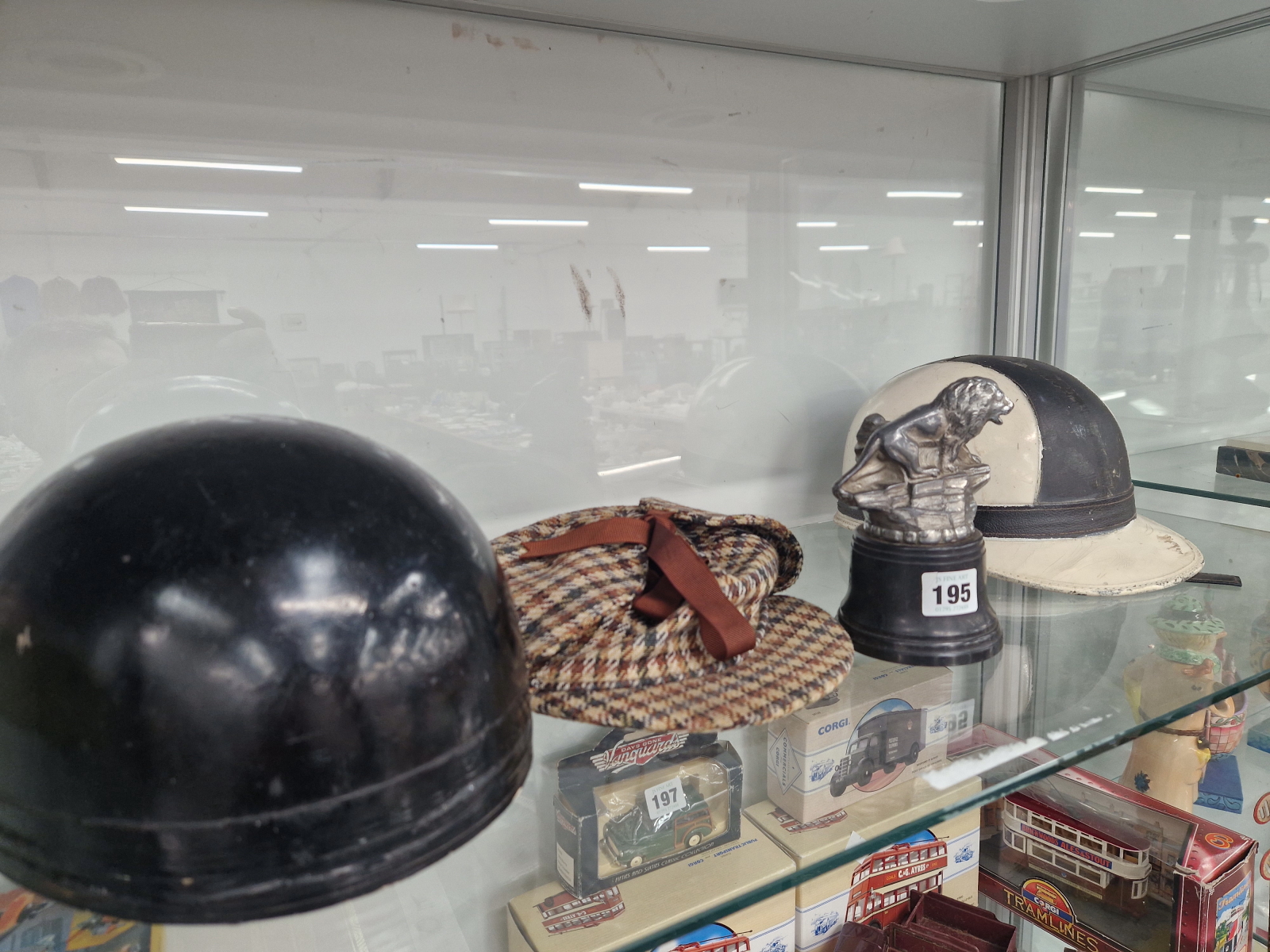 TWO RACING HELMETS, A DEERSTALKER HAT AND A METAL LION TROPHY