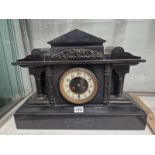 A BLACK SLATE CASED STRIKING MANTEL CLOCK