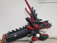 A BLACK AND RED PAINTED COMPOSITION  DRAGONS HEAD. L 90 H 80 D 50 cm