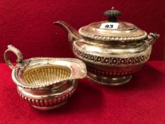 A LATE GEORGIAN HALLMARKED SILVER TEAPOT AND A LATER CREAMER