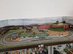 AN ELECTRIC TRAIN TRACK DIORAMA WITH A STATION A TUNNEL A HOUSE AND CARS